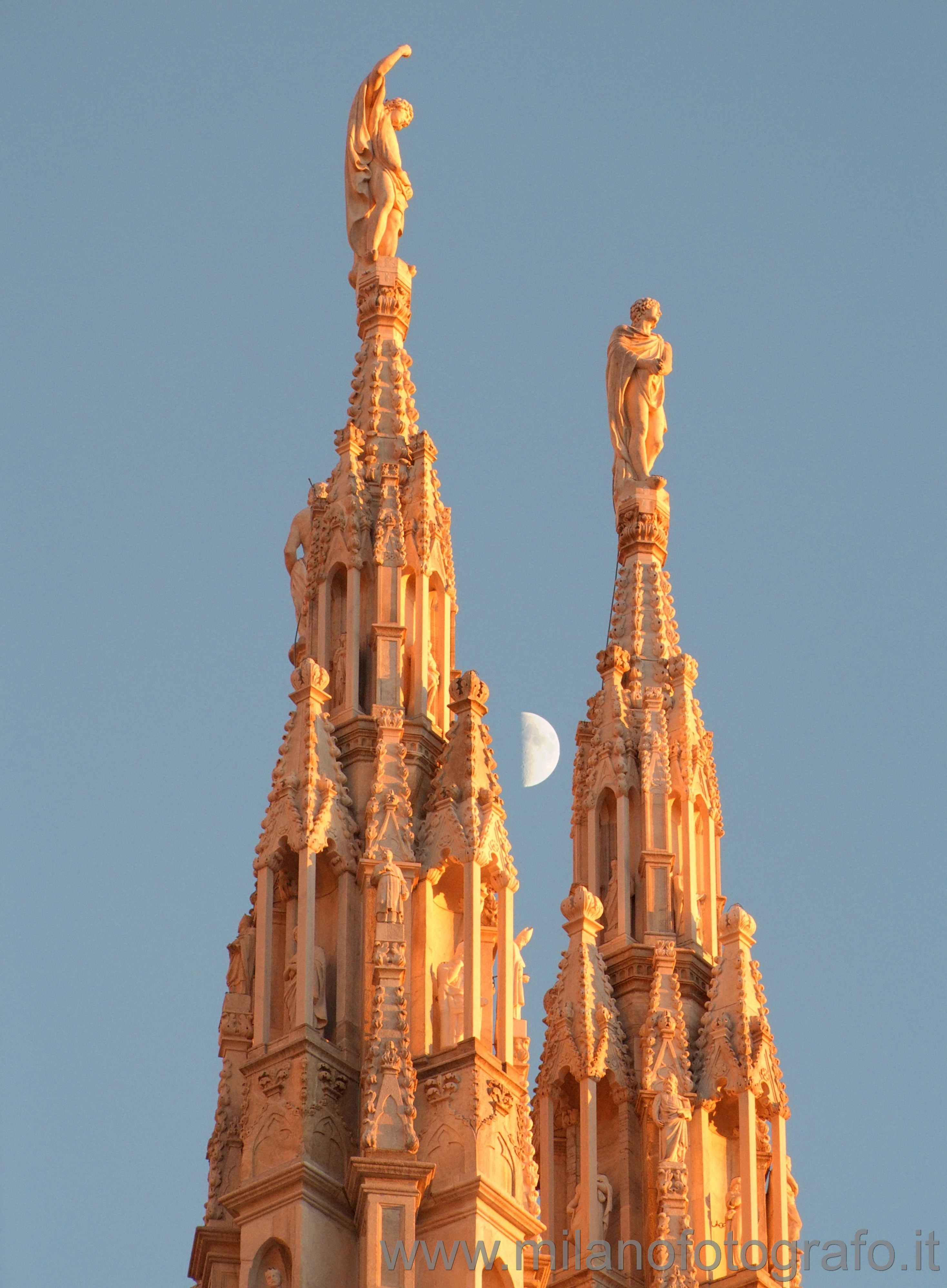 Milan (Italy) - Two pinnacles of the Duomo at dusk with the moon in the background