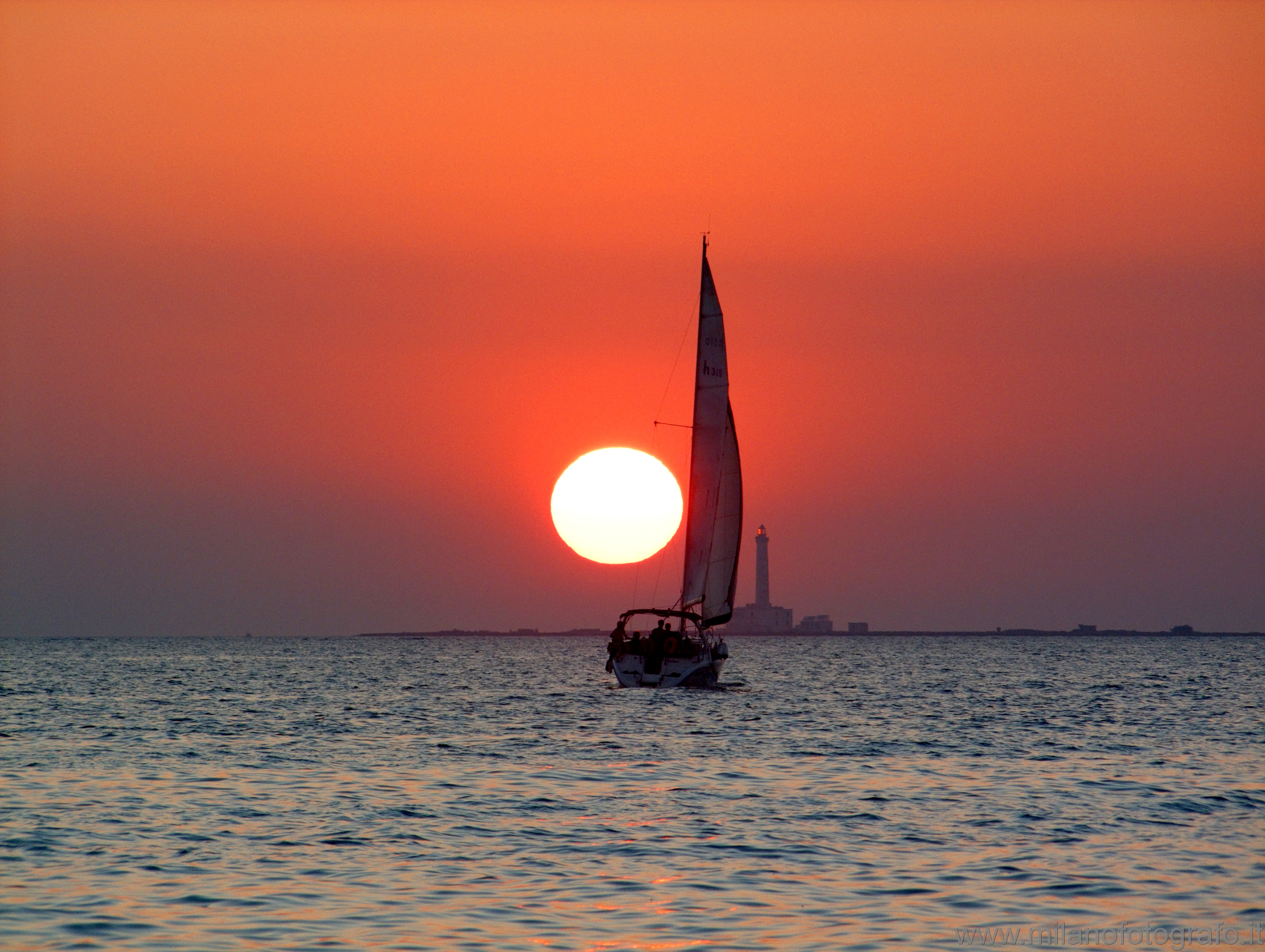 Baia Verde frazione di Gallipoli (Lecce): Tramonto con faro e barca a vela - Baia Verde frazione di Gallipoli (Lecce)