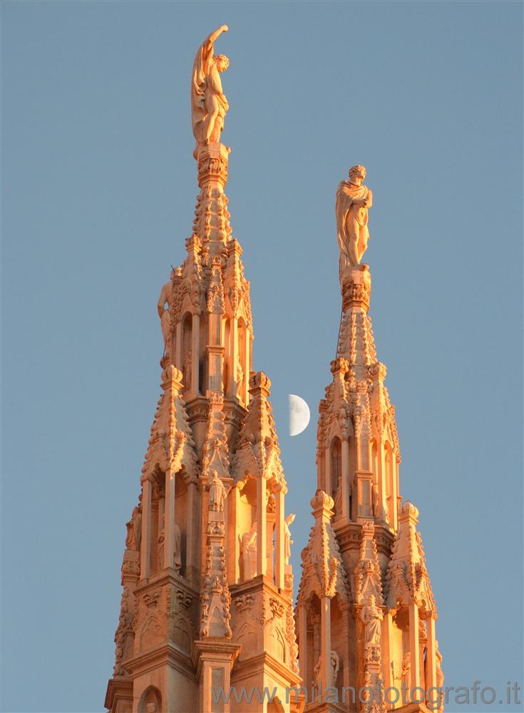 Milan (Italy) - Two pinnacles of the Duomo at dusk with the moon in the background