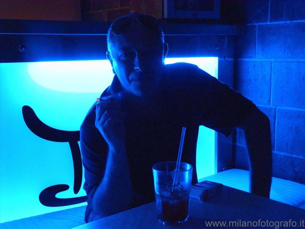 Milan (Italy) - Smoking person illuminated from behind by blue light