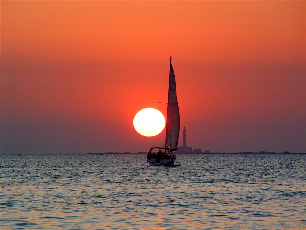 Baia Verde fraction of Gallipoli (Lecce, Italy) - Sunset with lighthouse and sailing boat