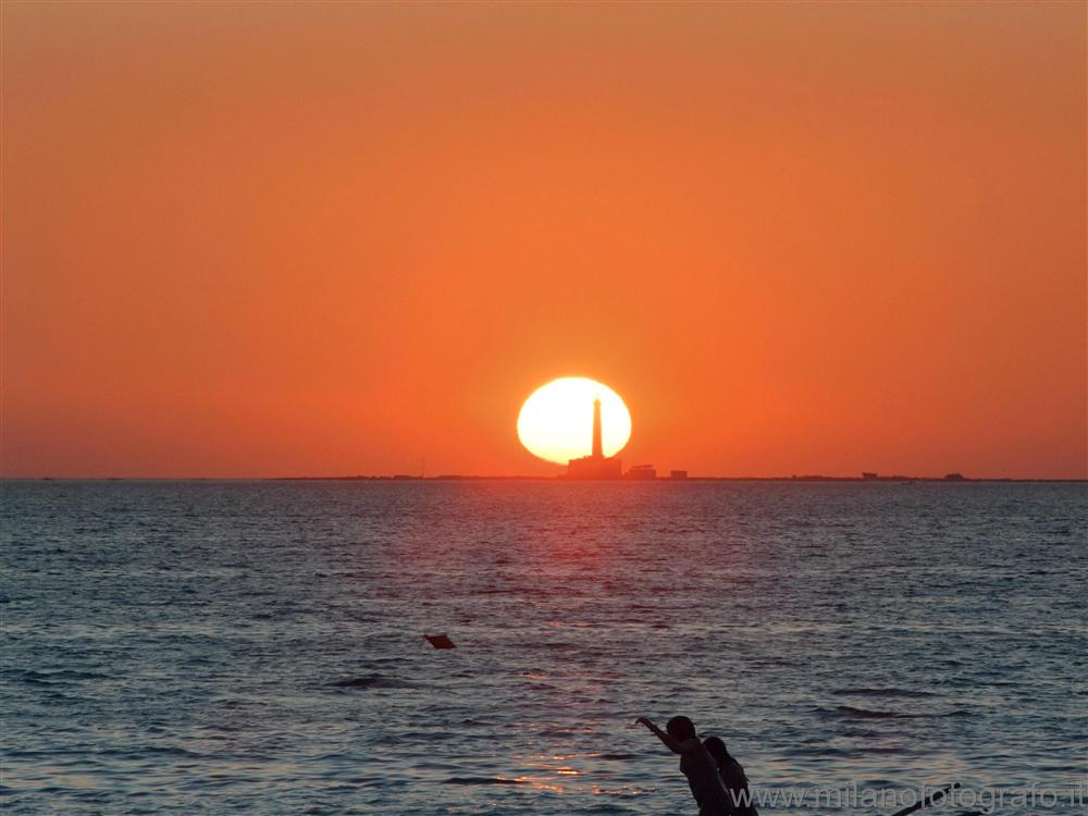 Baia Verde fraction of Gallipoli (Lecce, Italy) - Sunset sun skewered by the lighthouse