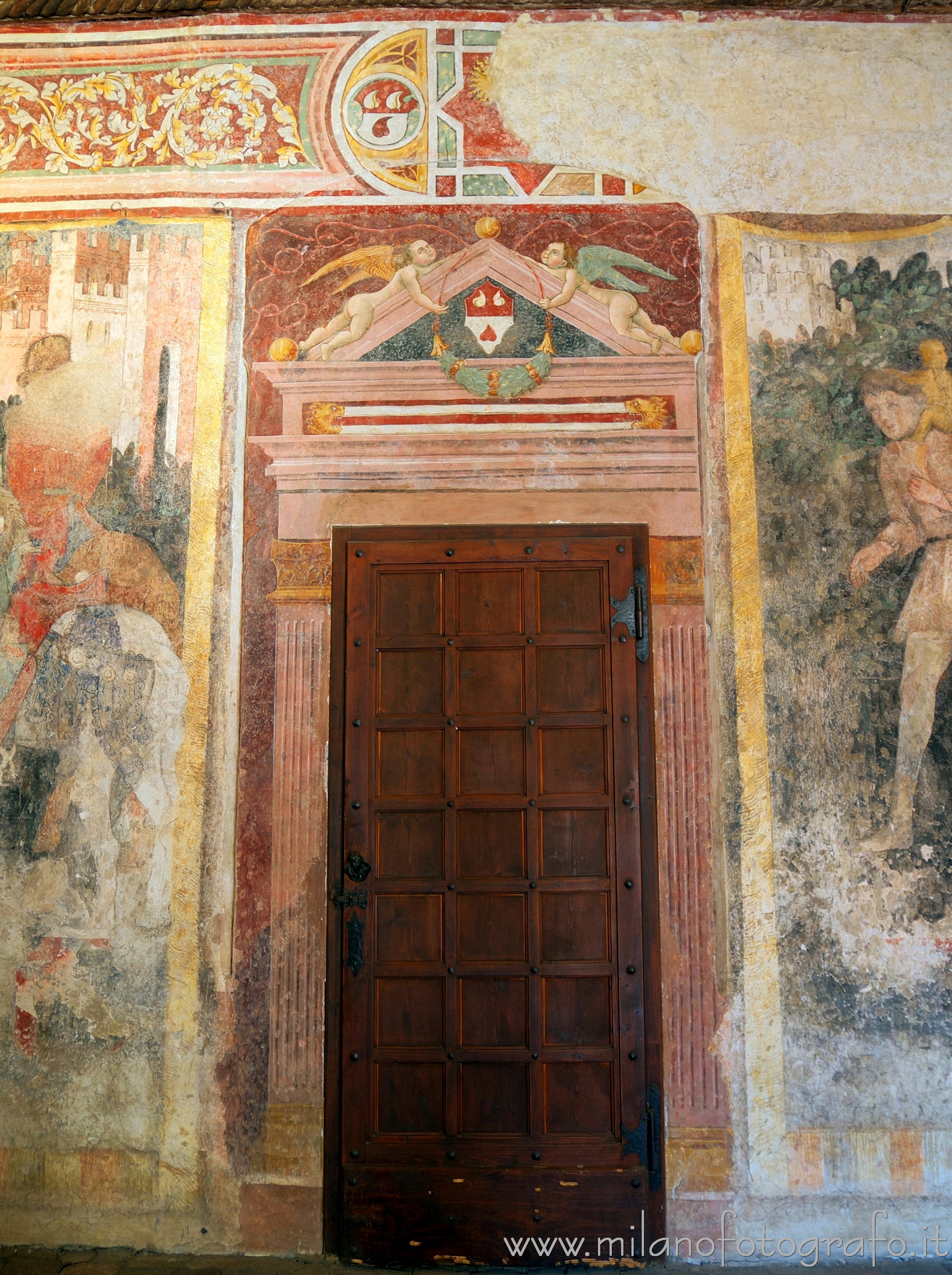 Cavernago (Bergamo, Italy): Door surrounded by frescoes in the court of the Malpaga Castle - Cavernago (Bergamo, Italy)